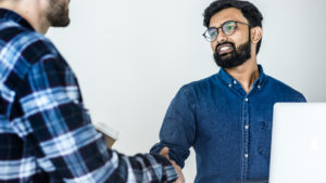 Diverse colleague men shaking hands together